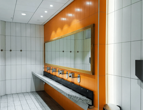 commercial public empty restroom with washstands mirror